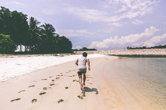 muž běží na pláži