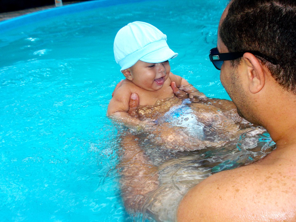 muž s dítětem v bazénu